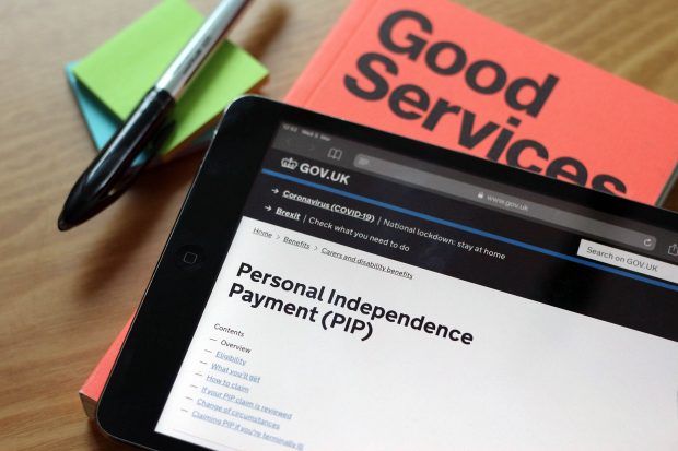 A tablet showing the Personal Independence Payment (PIP) guidance on GOV.UK next to a book saying Good Services