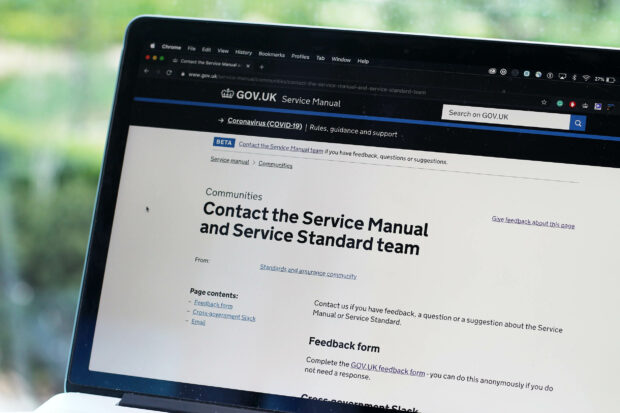 A laptop screen showing a web page on contacting the Service Manual and Service Standard team