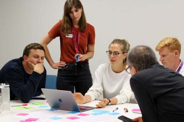 A small group of people in a workshop including two service designers and a user researcher